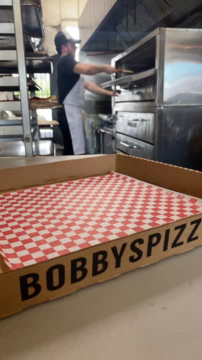 Inside Bobby's Pizzeria — slices coming out of the oven